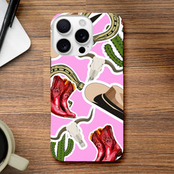 Pink Western iPhone case featuring red cowboy boots, cactus, horseshoe, and bull horn designs on a vibrant pink background.