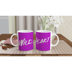 Two purple Cute Wild Heart Mugs with slogan coffee cups on a checkered table beside white flowers.