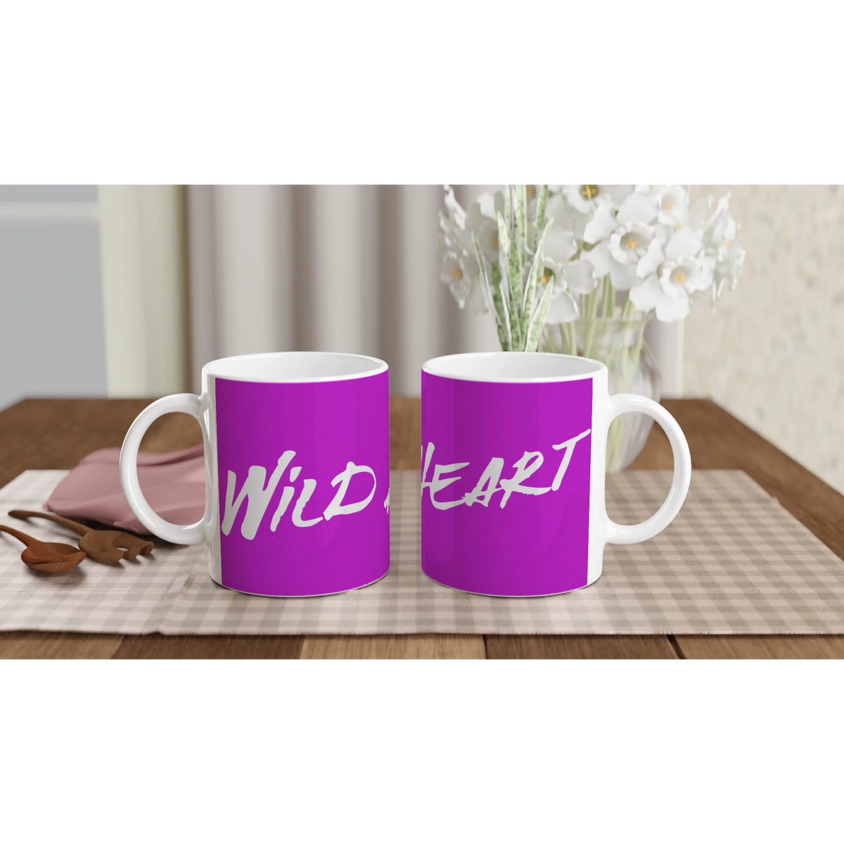 Two purple Cute Wild Heart Mugs with slogan coffee cups on a checkered table beside white flowers.