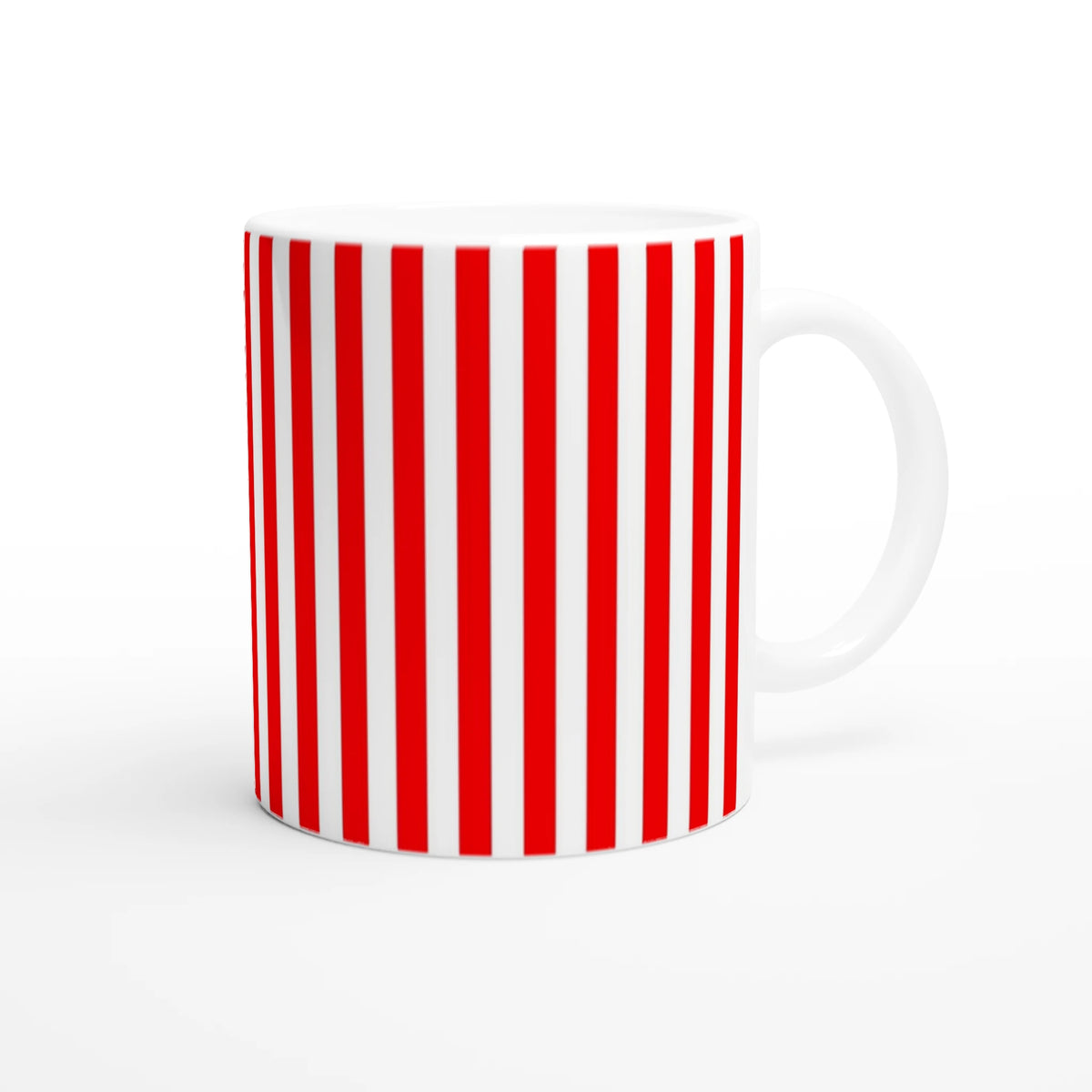 Red striped ceramic mug with candy cane pattern and white handle, retro coffee cup.