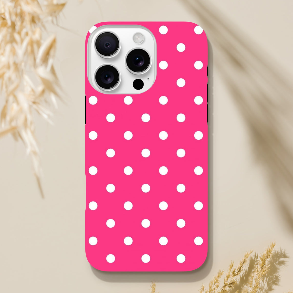 Hot pink iPhone case with white polka dots offering tough dual-layer shock absorption and rugged protection for daily use.