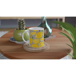 Cute Lemon Mug with citrus slice design on a wooden table beside a cactus and green vase.