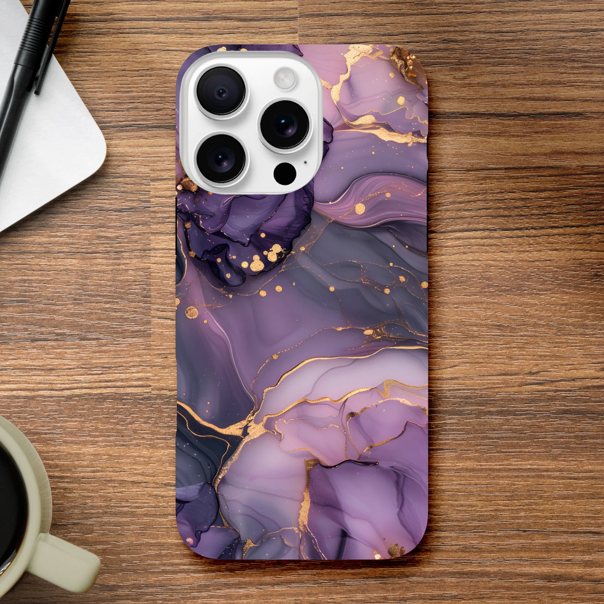 Luxury purple and gold marble abstract iPhone case with protective tough design resting on a wooden desk.