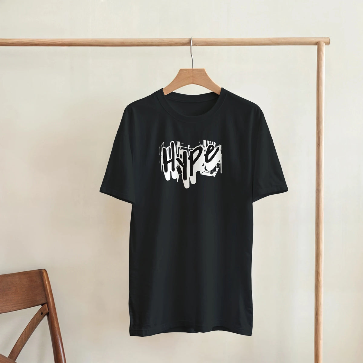 Black graffiti graphic tee on wooden hanger, urban streetwear for men.