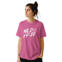 Woman wearing pink Cute Wild And Free T‑Shirt with bold white retro slogan.