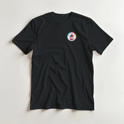 Black crew neck t-shirt featuring a small colorful circular Urban Palm Trees graphic on the chest.