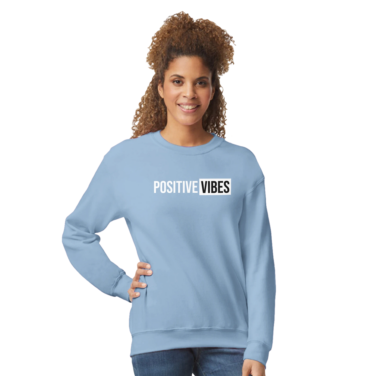 Woman in light-blue sweatshirt with POSITIVE VIBES slogan, casual streetwear style.