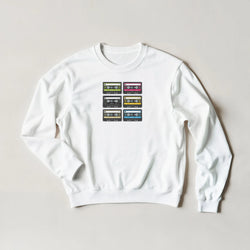 White sweatshirt featuring a grid of six colorful retro cassette tape prints, capturing vintage 90s music nostalgia.