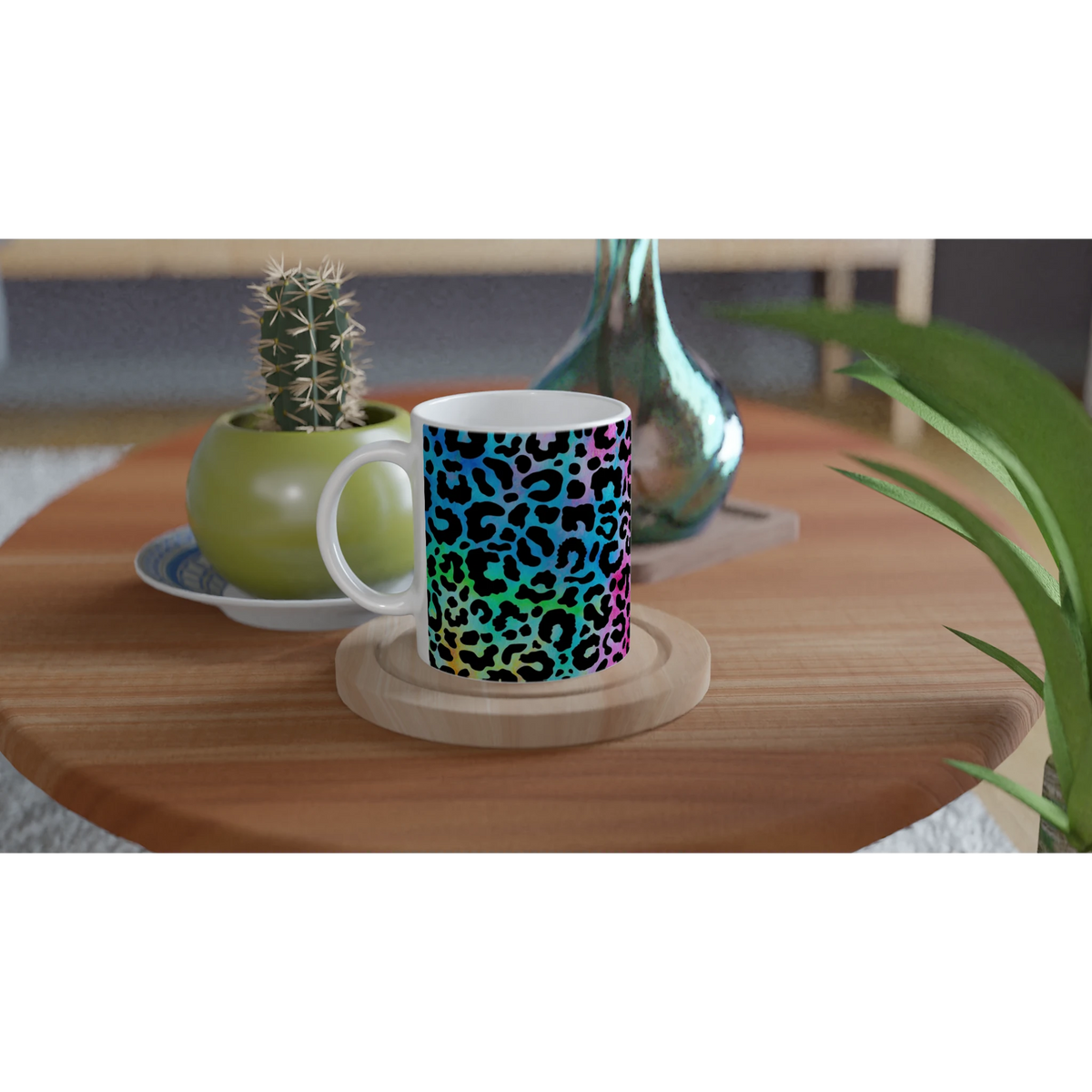 Rainbow leopard-print coffee mug on a wooden table beside a cactus and greenery.