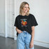 Woman wearing black California Beach graphic T-shirt with sunset palm design.