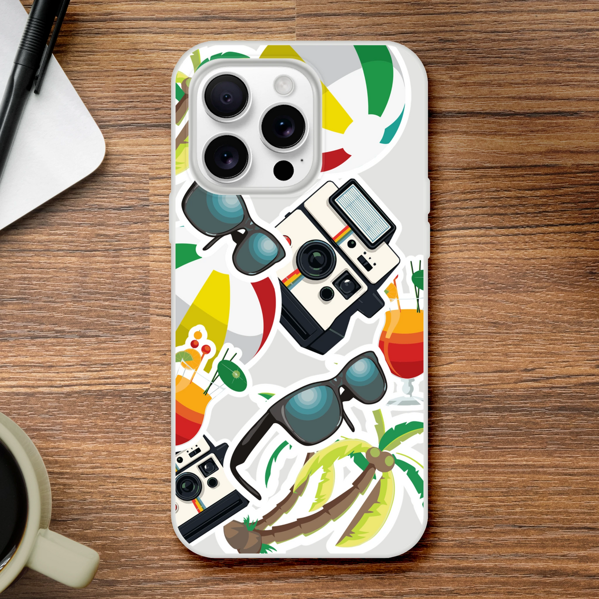 Transparent iPhone case featuring summer holiday sticker effects with palm trees, sunglasses, vintage cameras, and tropical cocktails on a wood background.
