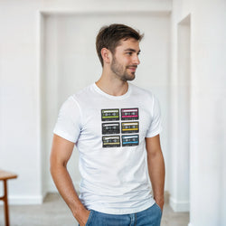 Man wearing white t-shirt featuring graphic of six colorful retro cassette tapes. 80s music streetwear top for audio nostalgia.