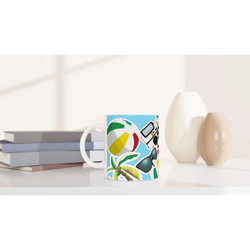 Summer holiday ceramic mug featuring a colorful beach ball, palm tree, sunglasses, and camera print on a bright blue background.