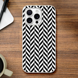 Black and white geometric herringbone iPhone case on wood. Shock-absorbing TPU phone cover with crisp matte finish for iPhone 13-16.