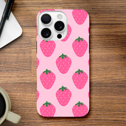 Pink strawberry pattern iPhone case with cute fruit design and high-gloss finish on wooden desk.