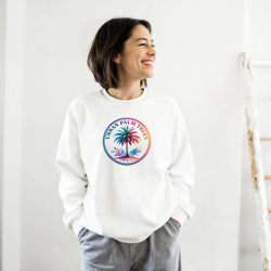 Smiling woman wearing a white Urban Palm Trees Sweatshirt with a colorful circular palm design.