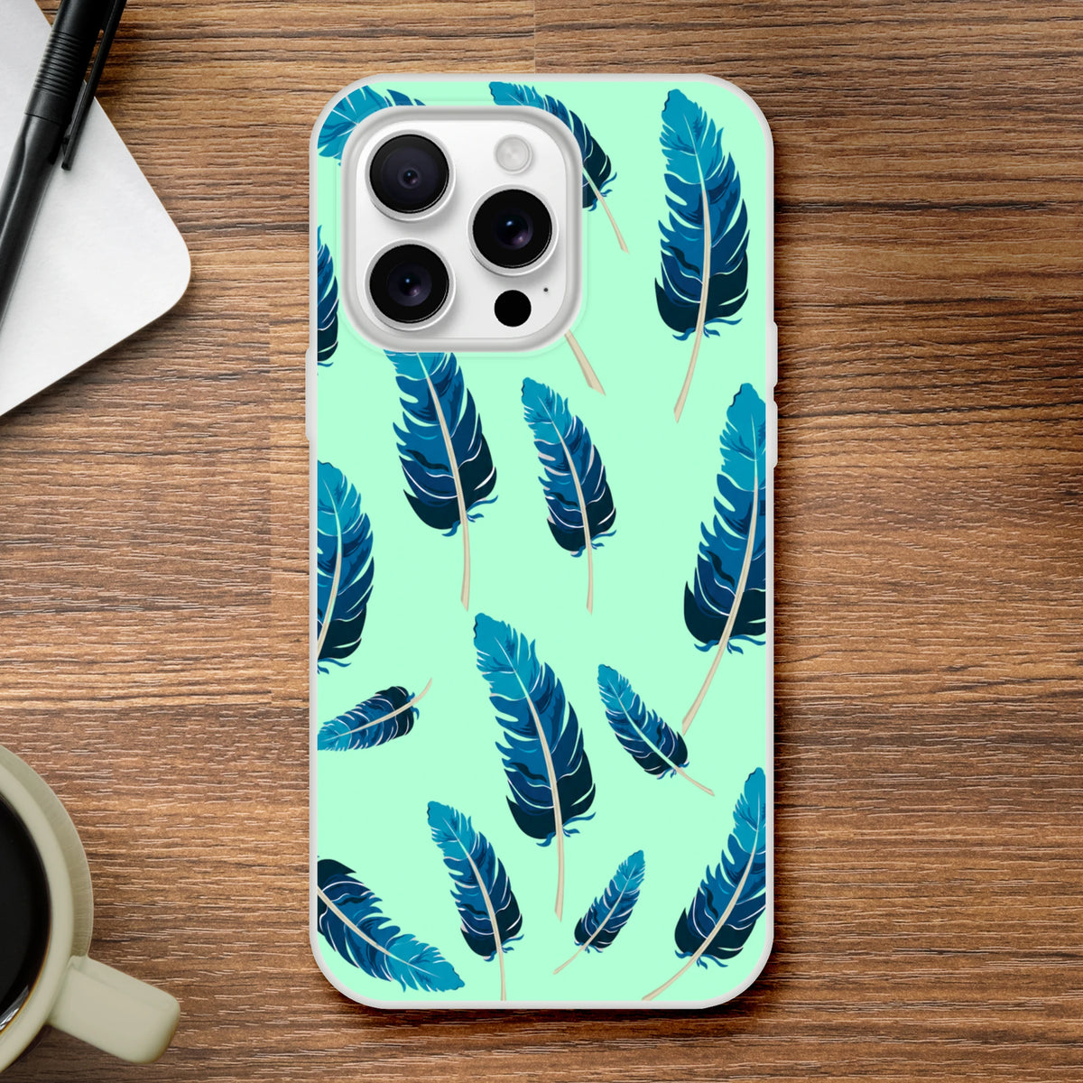 Mint-green aesthetic iPhone case with blue feather motif, matte finish and slim profile for iPhone 13–16