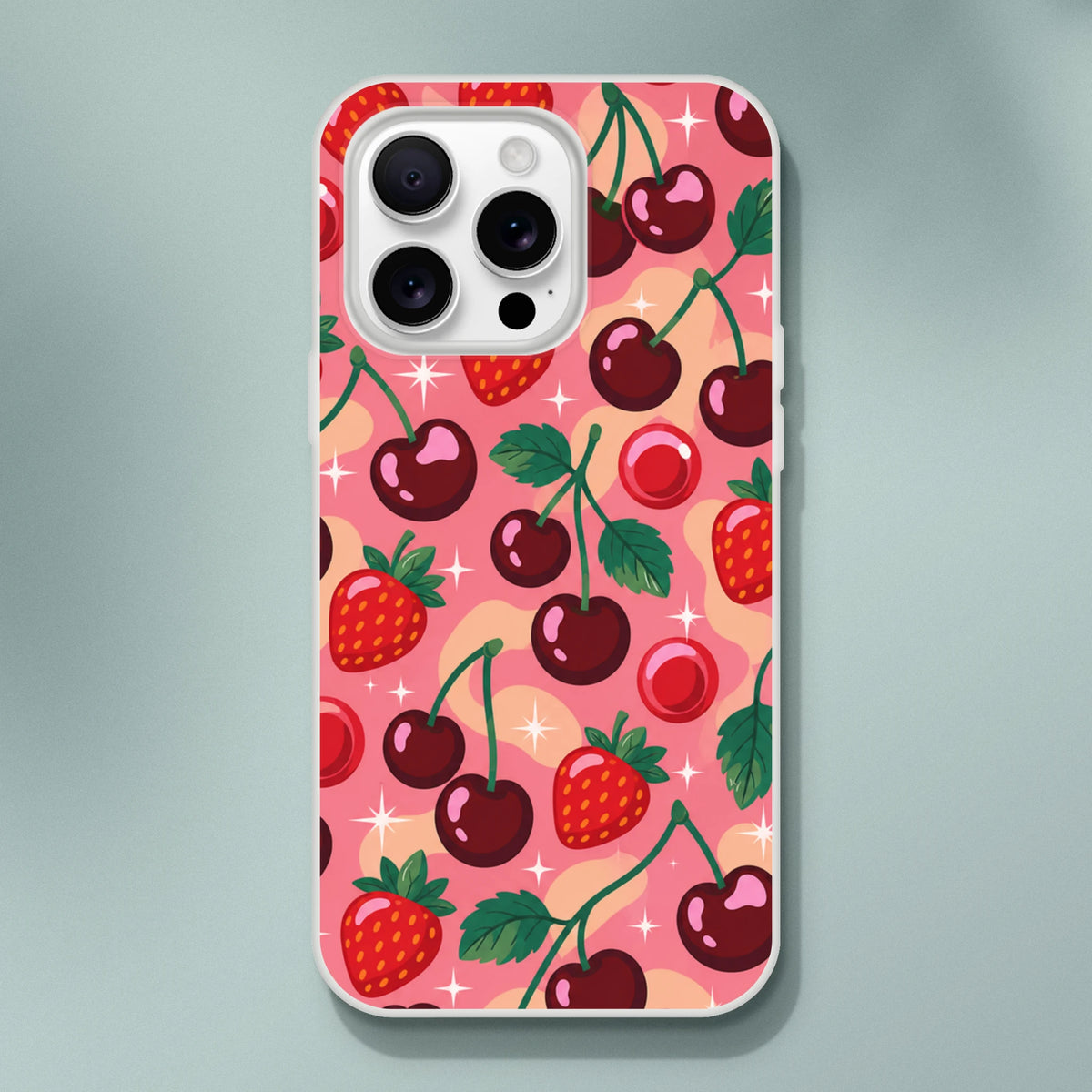 Retro pink iPhone case featuring a pattern of red cherries, strawberries, and sparkles. Shock-absorbing TPU cover for iPhone 13-16.