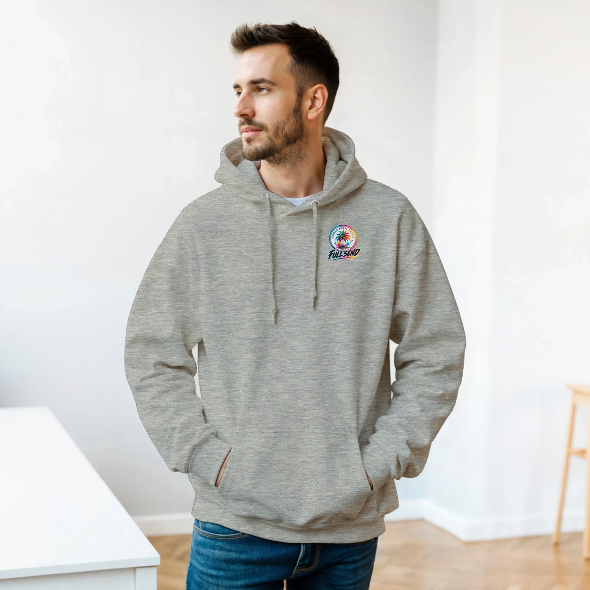 Man wearing grey Built Not Bought car hoodie with colorful palm tree chest logo. Petrolhead streetwear sweatshirt with double-lined hood and matching drawstring.