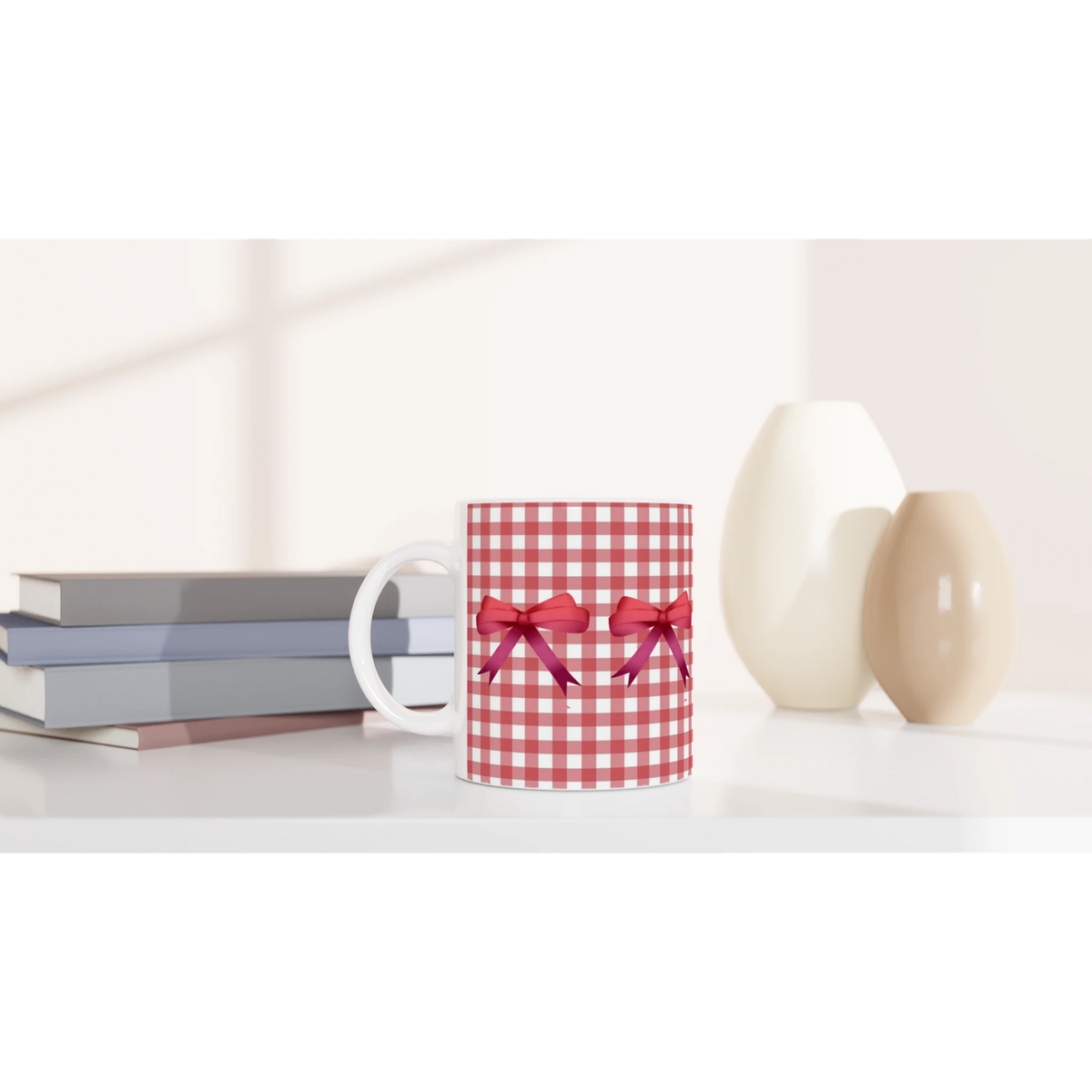 Red Gingham Bow Mug on a white desk beside a red gingham gift box with a ribbon.