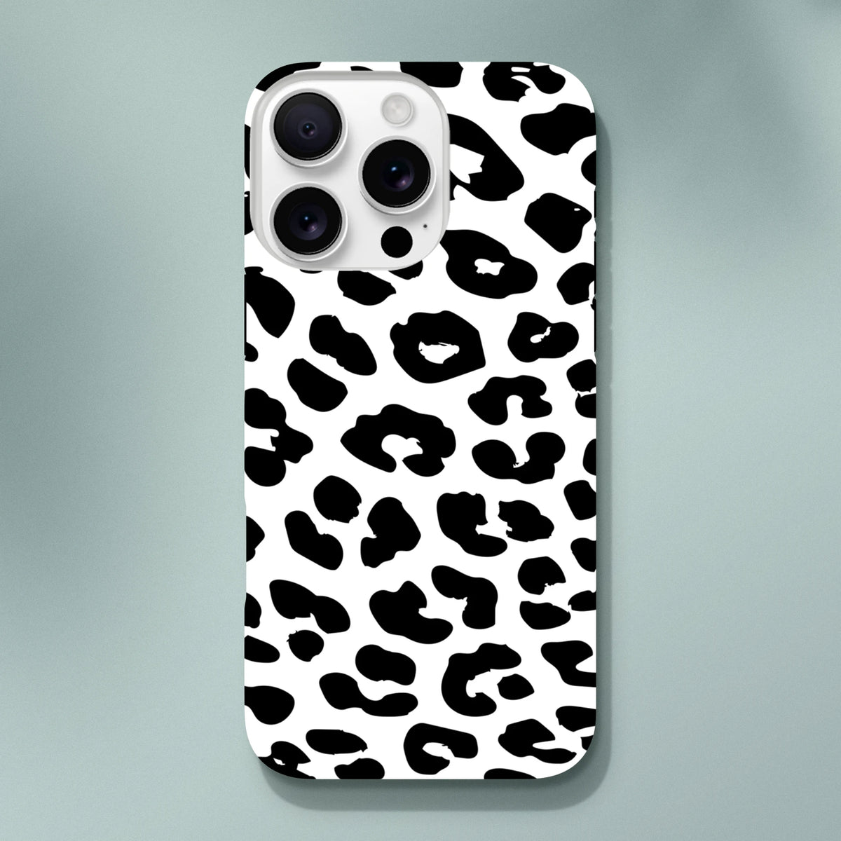 White iPhone case featuring a bold black snow leopard animal print pattern with a tough, shock-absorbing design for daily protection.