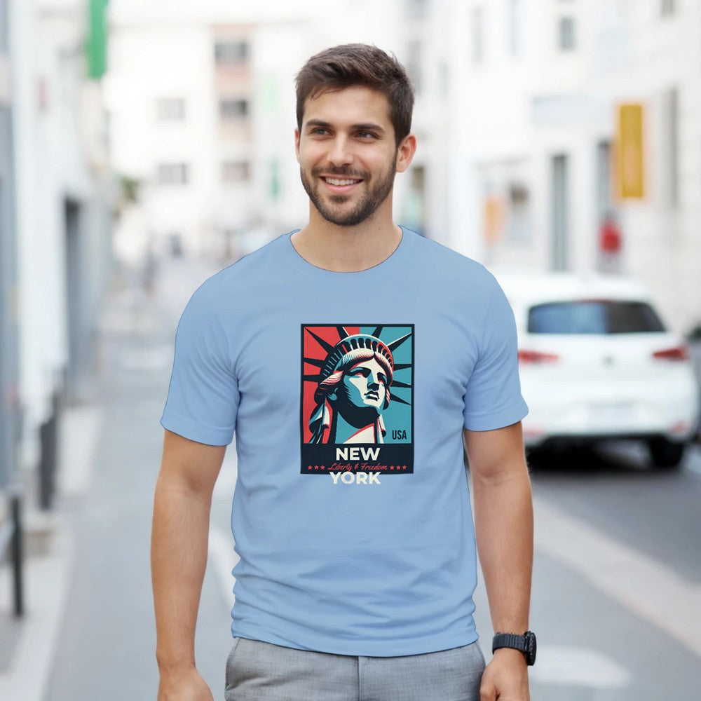 Man wearing light blue New York graphic T-shirt with Statue of Liberty artwork; sizes S–XL.