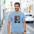 Man wearing light blue New York graphic T-shirt with Statue of Liberty artwork; sizes S–XL.