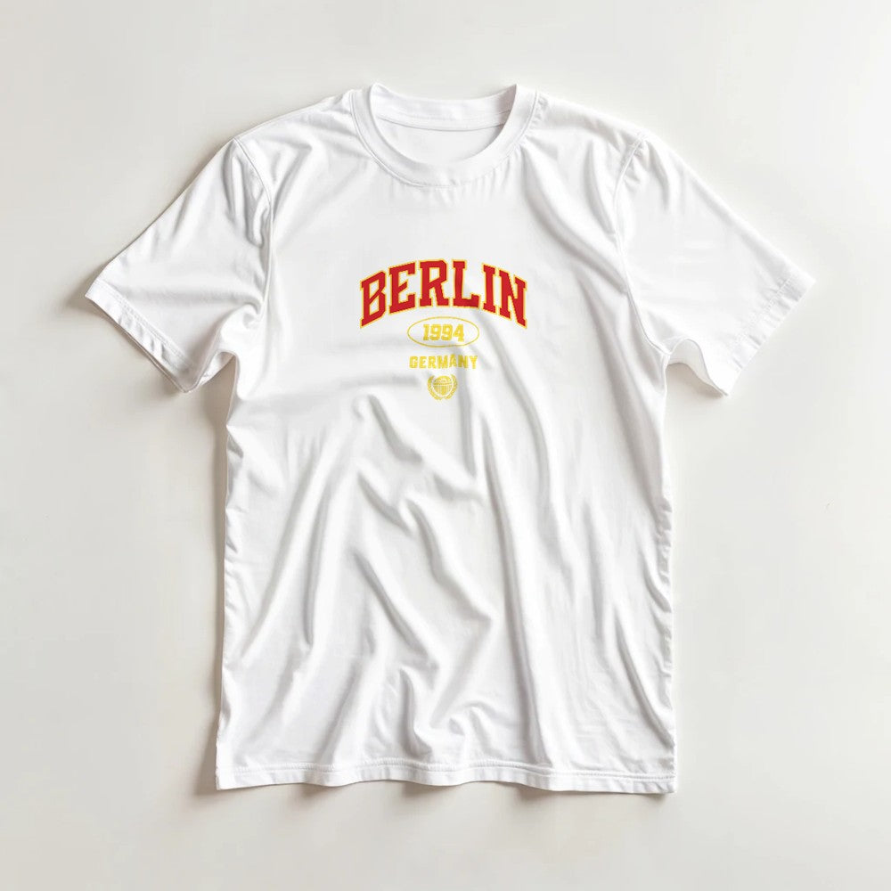 White women's Berlin cotton blend graphic T-shirt with red BERLIN and yellow 1994 Germany design, short sleeves.