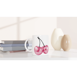 Cute Glitter Cherries retro coffee cup with pink glitter cherries on white ceramic on a desk.