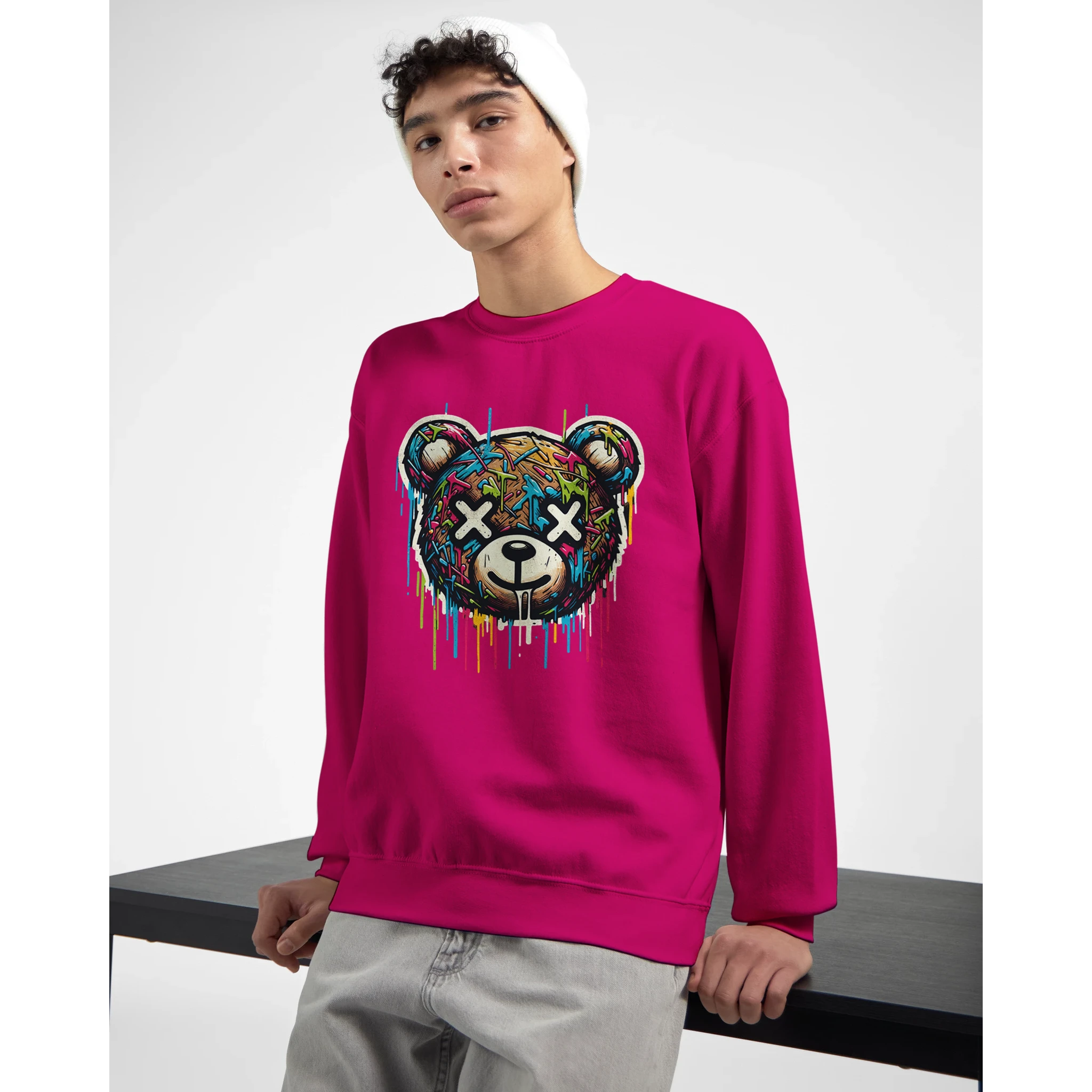 Male model wearing bright pink Teddy Bear graphic sweatshirt with dripping multicolor art and X-eyed bear.