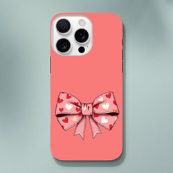 Pink iPhone case with a large bow patterned with red and white hearts on a coral background. Cute coquette tough phone cover.