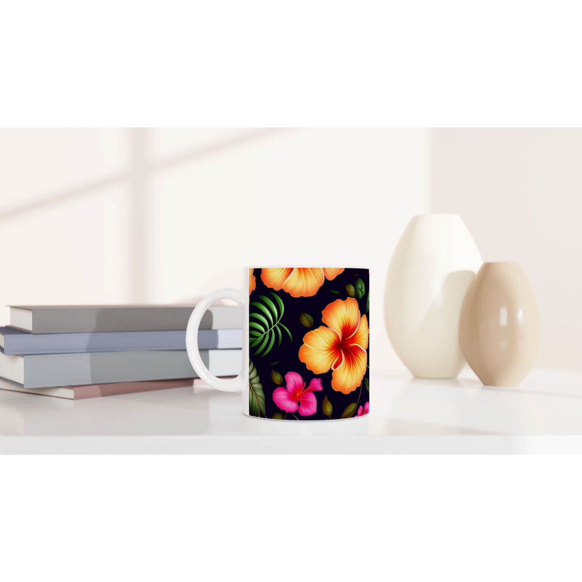 Tropical Hibiscus Mug with vibrant orange flowers and green leaves on a dark background, on a white desk beside books.
