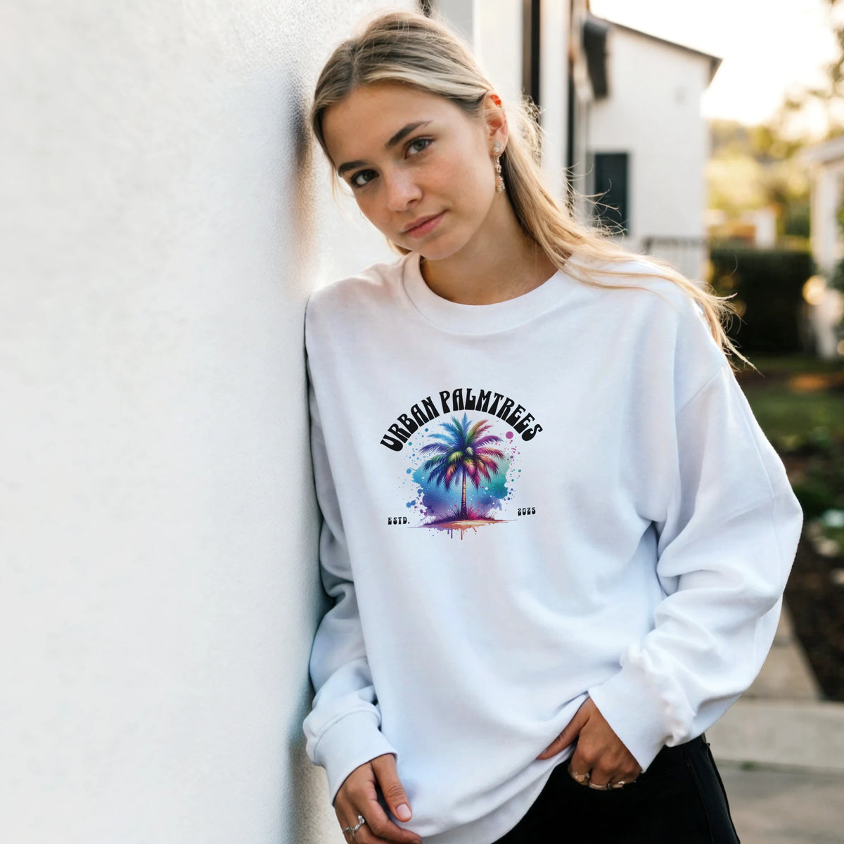 Woman wearing Urban Palm Trees Sweatshirt with pastel palm graphic, casual outdoor style.