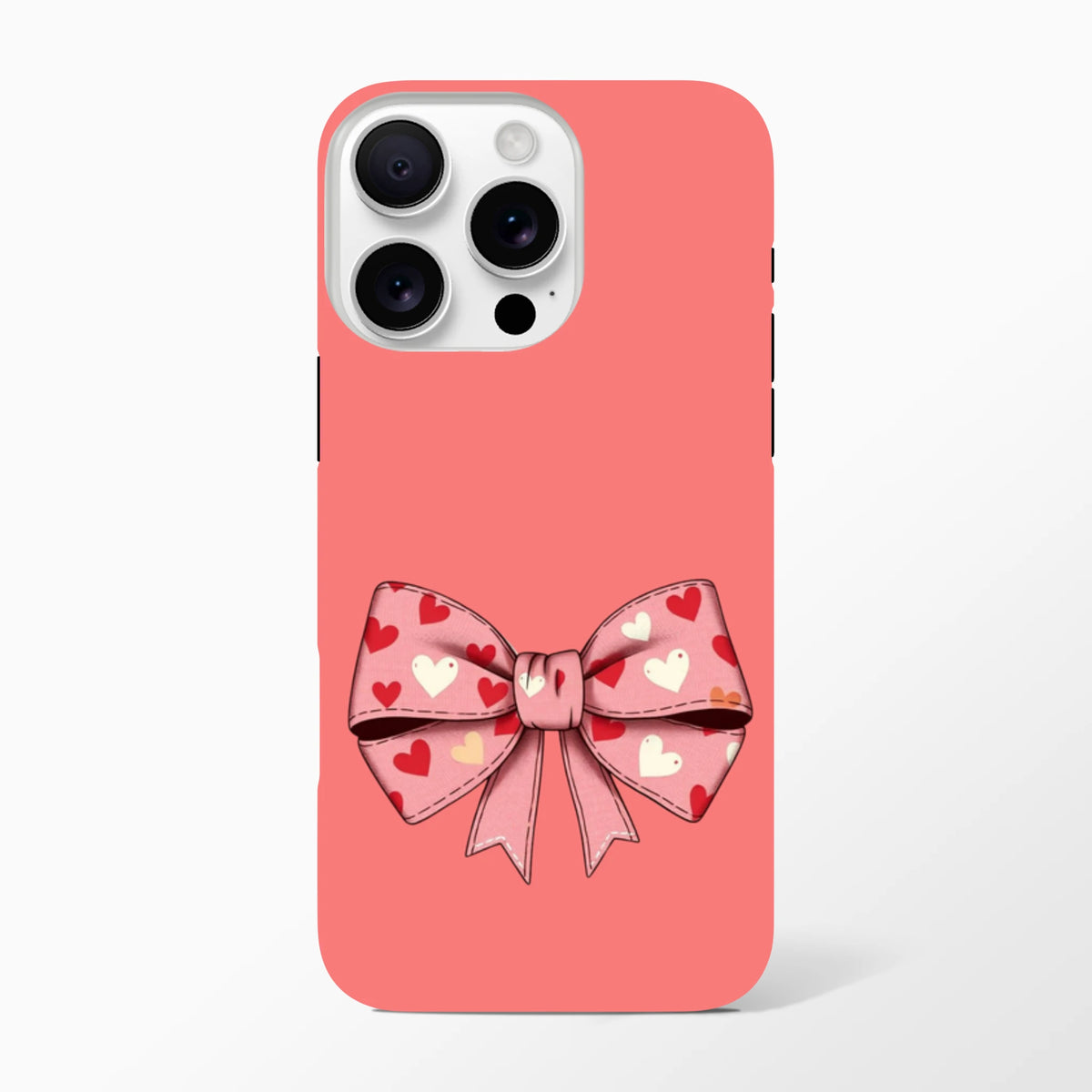 Coral pink iPhone case featuring a large pink bow with red and white heart pattern, embodying a cute coquette aesthetic.