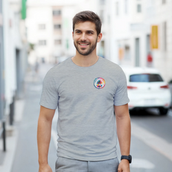 Man wearing grey t-shirt with colorful circular Urban Palm Trees logo on chest while walking down a city street.