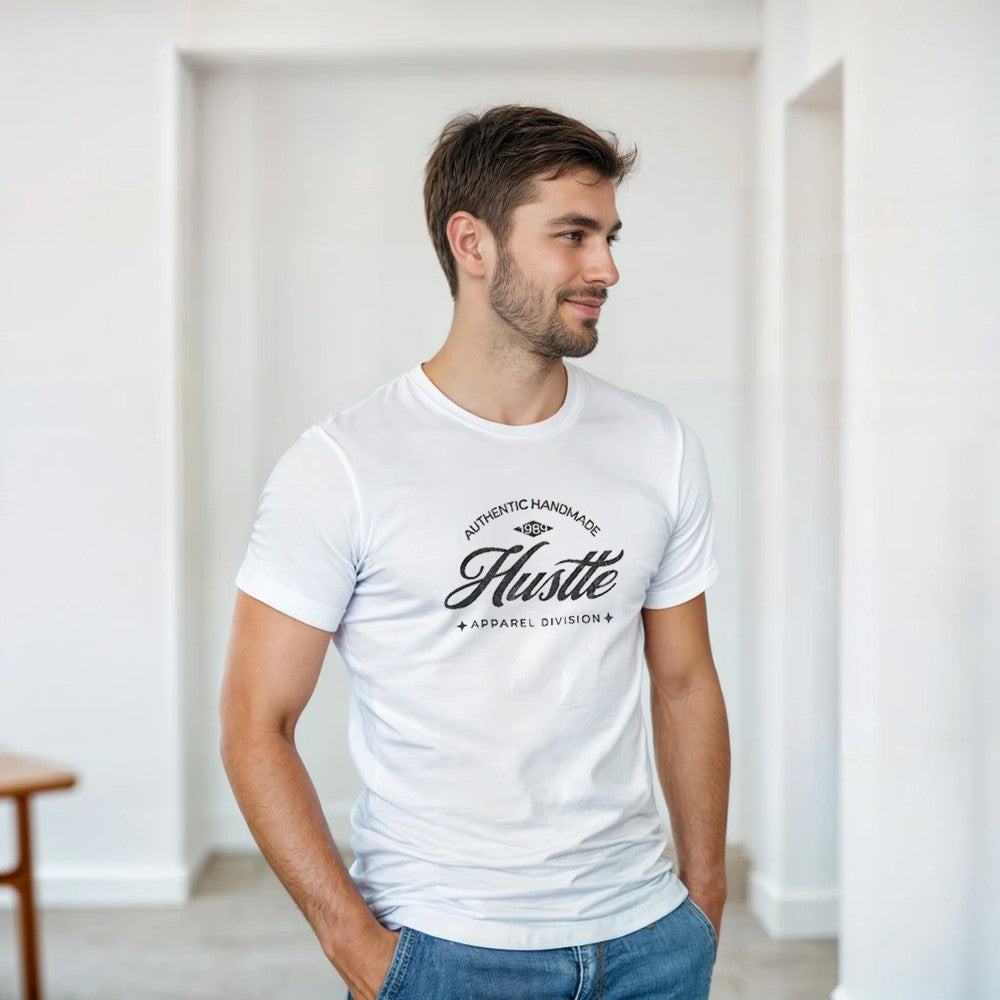 Man wearing white Hustle graphic T-shirt with bold Hustle logo in a casual indoor setting.
