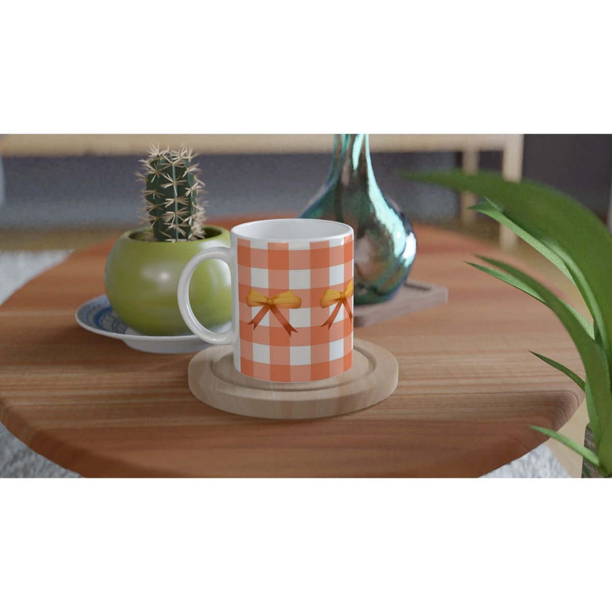 Orange gingham bow mug on a wooden table, with a small cactus and vase nearby.