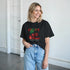 Woman in black Cherries Blaze graphic T-shirt with cherry illustration and red text, paired with light blue jeans.