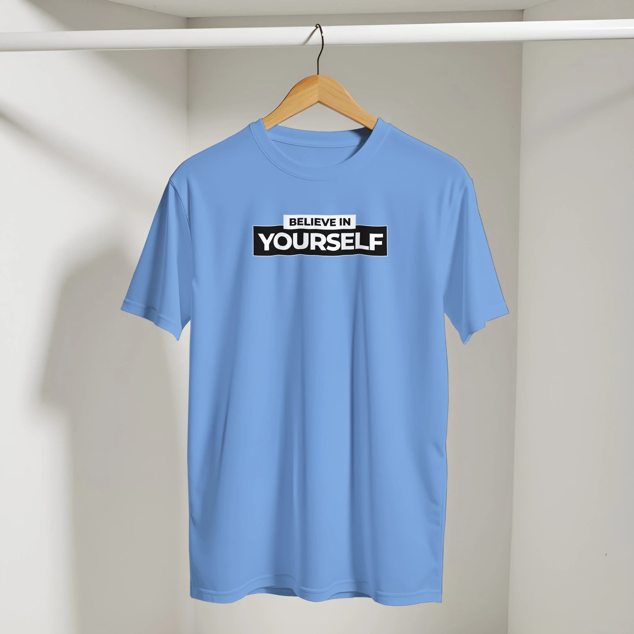 Blue Believe In Yourself t-shirt on hanger with bold retro slogan graphic.