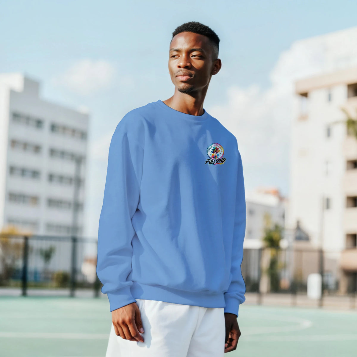 Man wearing a light blue crew-neck sweatshirt featuring a colorful palm tree and "Full Send" graphic on the chest.