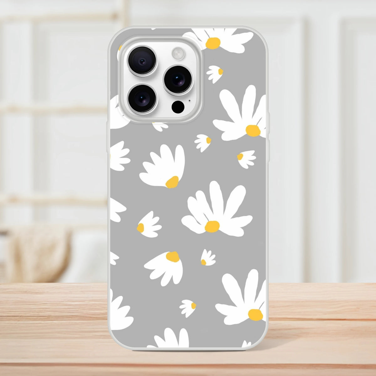 Ditsy Daisy slim iPhone case with floral gray background, white daisies and yellow centers, matte finish.