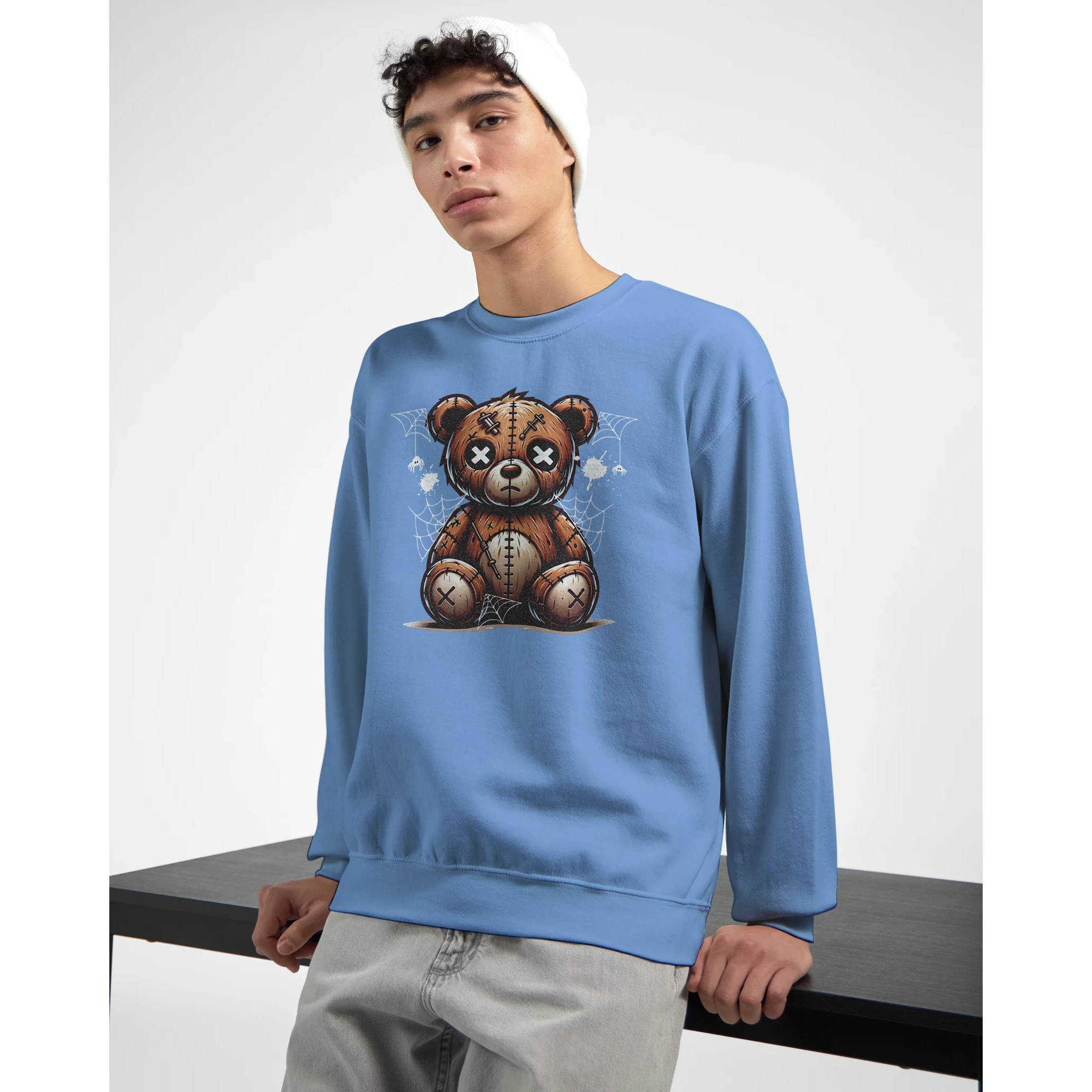 Blue men's graphic sweatshirt with a stressed teddy bear design worn by a model.