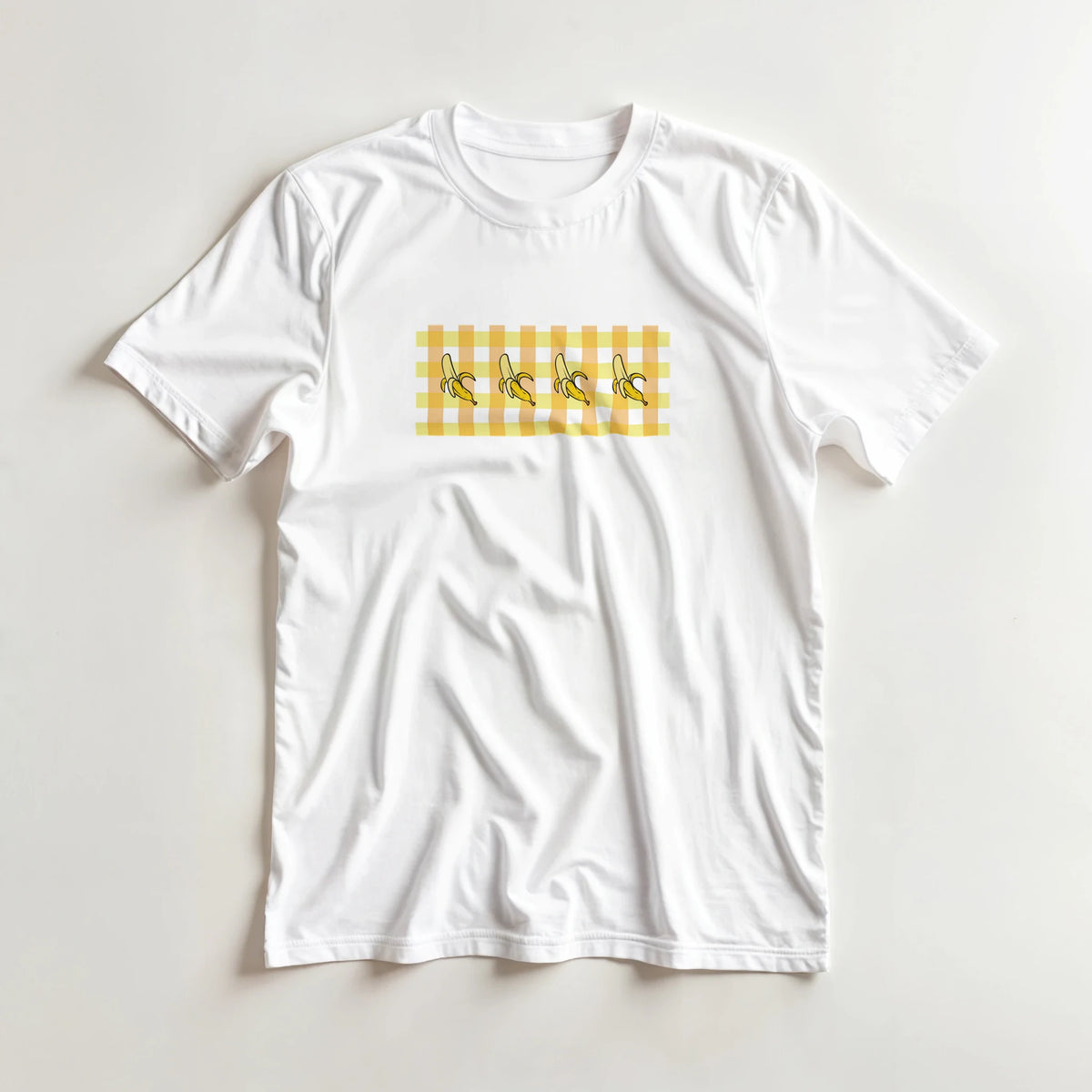 White women's t-shirt with a yellow banana-gingham print featuring bananas across a gingham panel.
