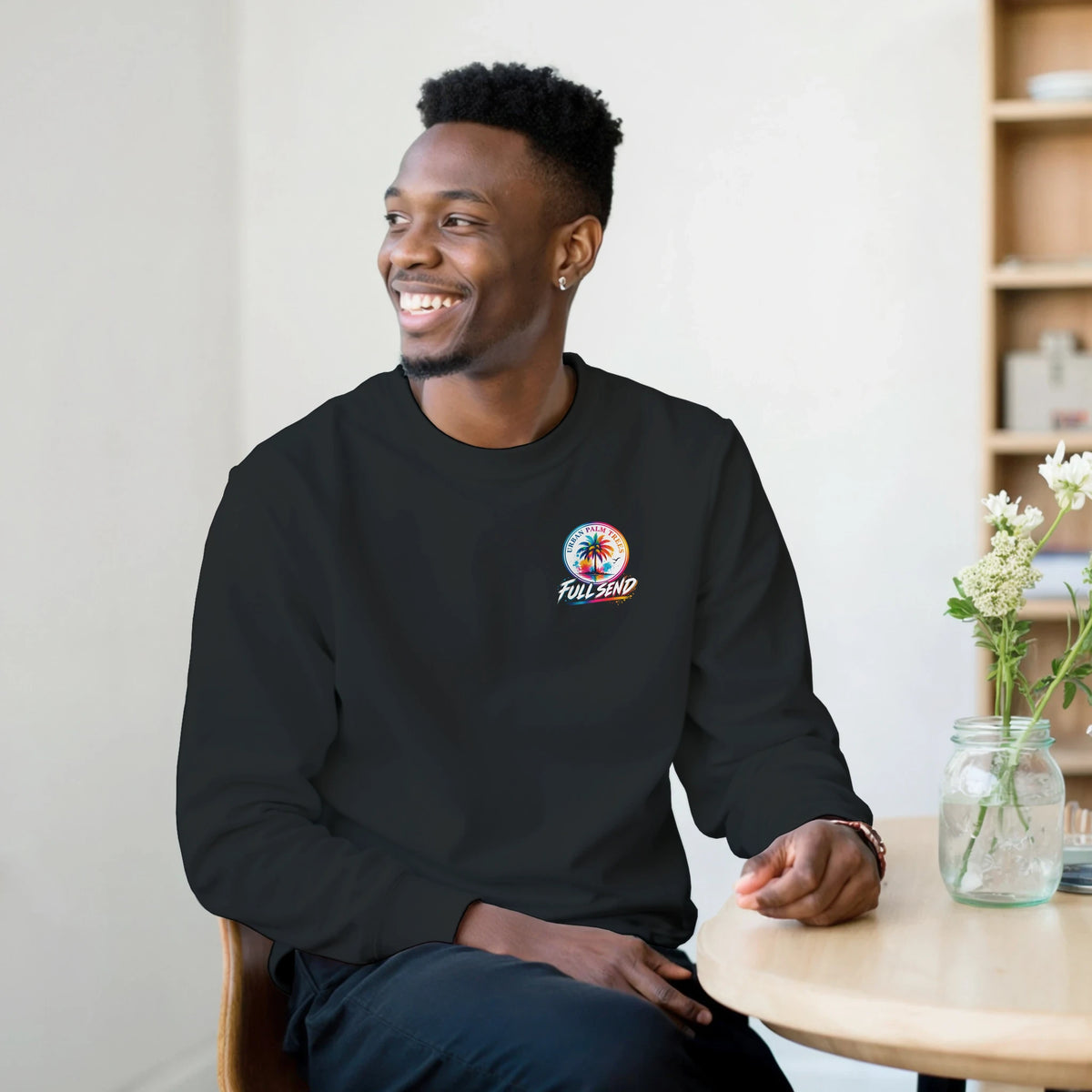 Man wearing a black Full Send sweatshirt featuring a colorful Urban Palm Trees graphic logo on the chest.