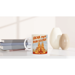 Vintage Barcelona mug with retro postcard design Hola from Barcelona; coffee cup on a white desk.