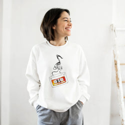 Smiling woman wearing a white Retro Cassette Tape sweatshirt with a vintage cassette graphic