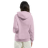 Back view of a woman wearing a pink cotton-blend hoodie with hood up and white pants.