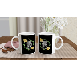 Pair of white ceramic mugs with black panels reading GOOD VIBES ONLY, surrounded by a yellow rose floral wreath.