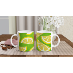 Two ceramic mugs with lemon-slice designs on a bright green background, set on a checkered table.