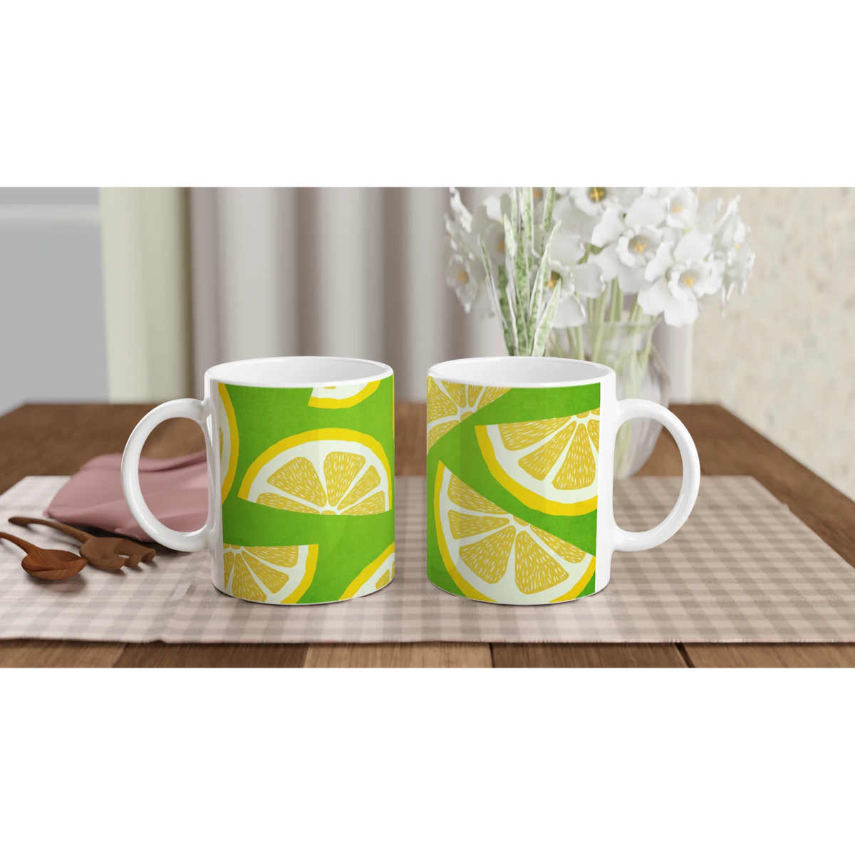 Two ceramic mugs with lemon-slice designs on a bright green background, set on a checkered table.